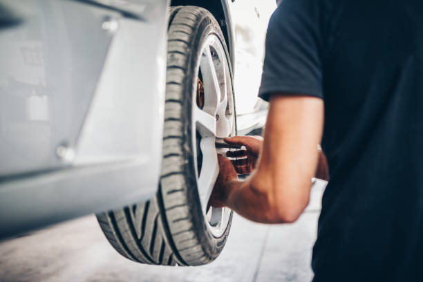 man changing a car wheel in tire fitting